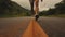 Legs of a person walking along a country road