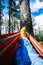 Legs point of view of outdoor leisure activity and relax on colorful hammock in the woods forest between trees - people and active