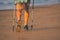 Legs and poles of nordic walker old woman on the beach