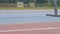 Legs in red snikers of a young woman jog athlete who training running at the city athletics stadium during a day