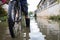 Legs with rubber boots in flooding,Asian man wear waterproof boots with his old bicycle in flooding,after heavy rainfall on the