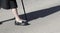 Legs of senior woman in black crossing the street with a cane