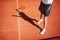 Legs and shadow of tennis player on tennis court