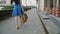 Legs slender young woman, walking in the city past the store with shopping bags, back view, slow mo, stedicam shot