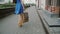 Legs slender young woman, walking in the city past the store with shopping bags, back view, slow mo, stedicam shot