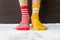 Legs in socks two colors alternate, Red and yellow side stand on white fabric floor.