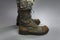 Legs of a soldier in camouflage and army boots on a gray background. Military conflicts and crises. Close-up