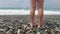 Legs of a teen girl on the beach at the daytime. Young girl walking on the sea.