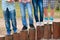 Legs of teenagers standing on wooden columns