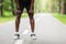 Legs of tired black sportsman resting after training