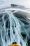 Legs of a tourist on the lines of cracks in the ice of Lake Baikal near the island of Olkhon in winter