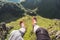 Legs traveler relaxing and hanging on cliff with evergreen mountain