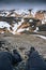 Legs of traveler relaxing on top of volcanic mountain with gloomy sky on Blahnjukur trail at Iceland