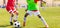 Legs of two African and European young football players on a match. Two soccer players running and kicking a soccer ball. Youth