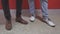 The legs of two men in shoes
