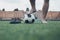 Legs of unrecognizable barefoot football player against artificial grass. Soccer ball, street football shoes. Copy space