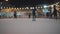 Legs of unrecognizable people ride on a city open ice rink in the evening. Winter skating public rink on Christmas Fair