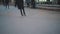 Legs of unrecognizable people ride on a city open ice rink in the evening. Winter skating public rink on Christmas Fair