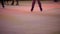 Legs of unrecognizable people ride on a city open ice rink in the evening. Winter skating public rink on Christmas Fair