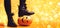 Legs of witch standing on scary pumpkin