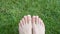 Legs of a woman on green grass in a meadow