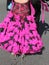 Legs of a woman with long fuchsia dress while dancing with a man