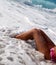 Legs of woman lying in surf