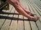 Legs of a woman sitting on a bench taking a sunbath