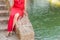 Legs of woman sitting on the wall of a staircase