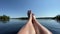 legs of woman on yellow kayak bow sailing along river water