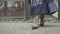 The legs of a young girl in a spring blue dress walk along the road