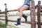 Legs of young woman cowgirl in shorts sitting on fence