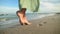 Legs of a young woman in slow motion walking barefoot on the beach. Leaving footprints in the sand Tourist on vacation