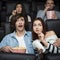 Leisure activity. Emotional young man with his girlfriend watching thriller in movie theater