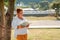 Leisure and education. An overweight woman in a suit reading a book in a Park, leaning on a tree trunk. Copy space