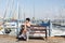 Leisure woman on holiday near yacht and sailboats marina resort town. Luxury lifestyle.