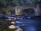 Leizaran river flows between the rocks under an old bridge in Andoain