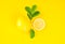 Lemo Lemons with slices and green leaves on bright yellow background.