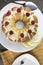 Lemon cake frosted with yellow sugar icing and red raspberries,