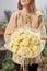 Lemon color mono bouquet of carnation in womans hands. European floral shop. the work of the florist at a flower shop