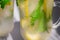 Lemon cooling drink mojito with ice in a glass with green mint leaves