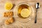 Lemon, creamy-peanut sausage, cup with tea on saucer, spoon on wooden table. Top view