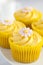 Lemon cupcakes with butter cream swirl and fondant flower decoration