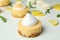 Lemon cupcakes, macaroons and ingredients on white