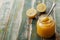 Lemon curd in glass jar on rustic wooden table, traditional fruit cream