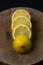 Lemon on a dark background. Sliced lemon on a wooden background.