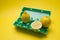 Lemon in egg carton on yellow background