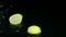 Lemon falls into the water and dissolves into slices. Black background. Slow motion