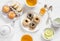Lemon green tea and sweets - banana muffins, cookies with caramel and nuts, donuts with chocolate and lemon glaze, tea set on whit