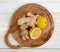 Lemon halves and ginger laid out on a wooden cutting board